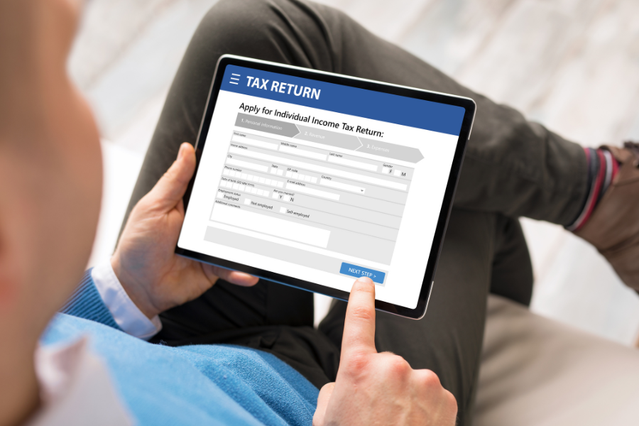 A person filling out a digital tax return on ipad. 
