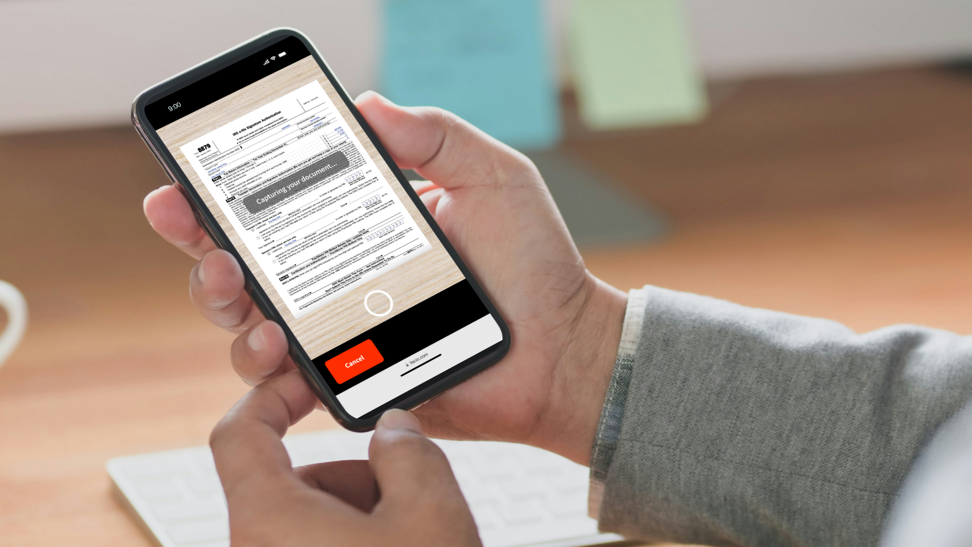 Hand holding a phone scanning a signed Form 8879 using the Liscio mobile scanner.