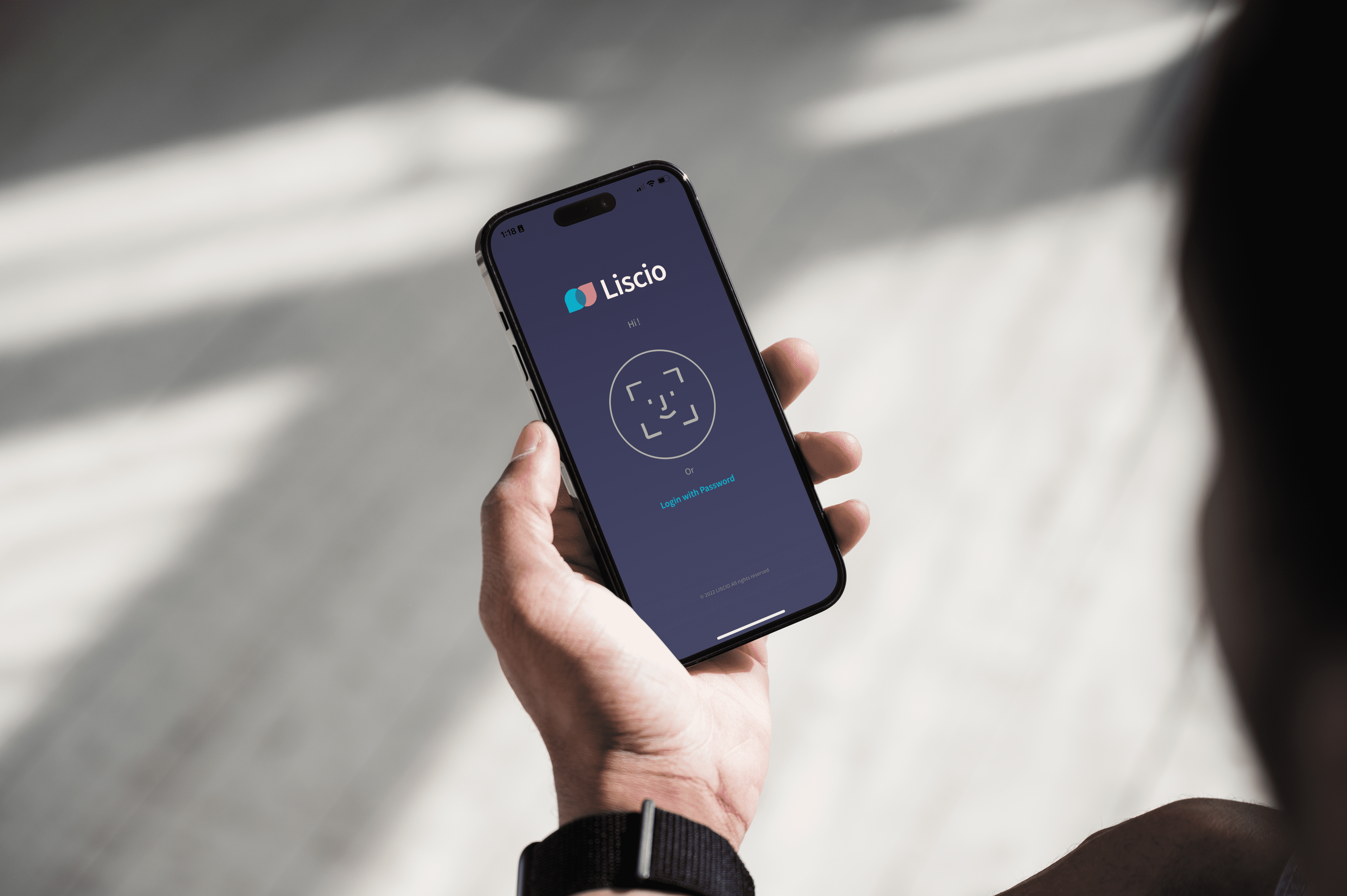Hand holding a phone showing the Liscio login screen with Face ID and password options.