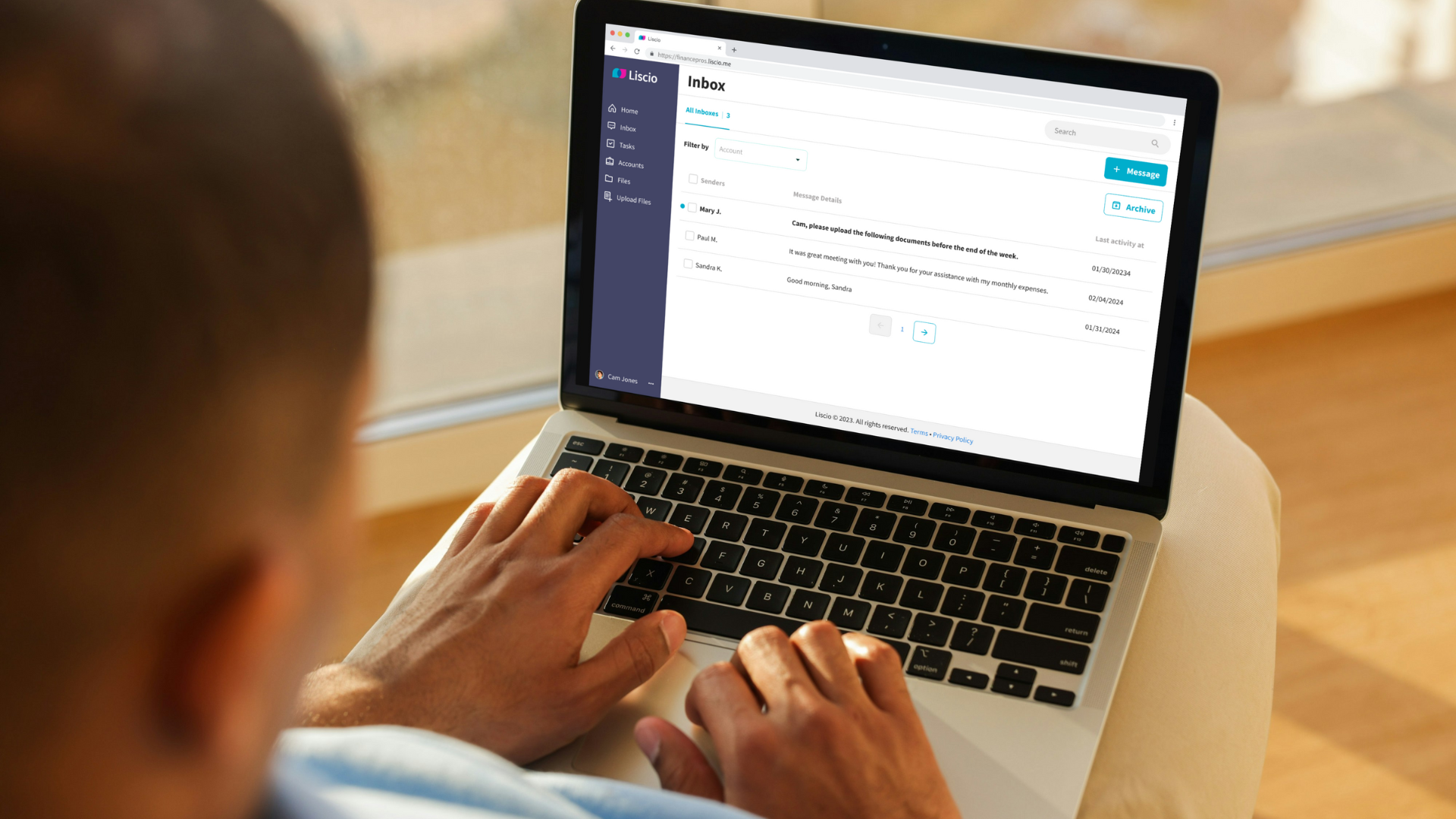 Person typing on a laptop showing the Liscio inbox with client messages.